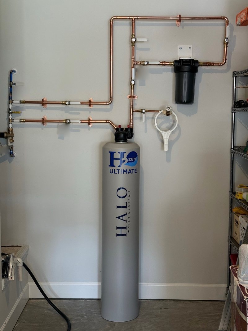 Whole-home water filtration tank on a copper manifold in a garage